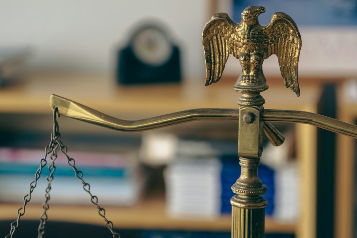 Scales of justice on an office desk with an eagle statue